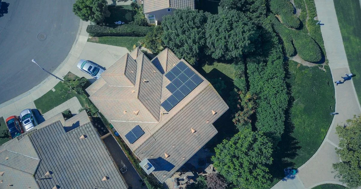 Une vue aérienne mettant en valeur des maisons suburbaines modernes équipées de panneaux solaires pour une énergie renouvelable.