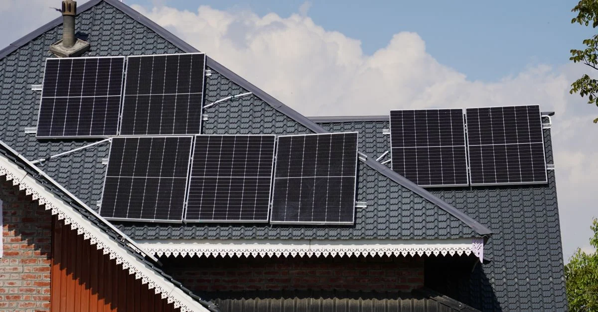 Panneaux solaires sur le toit d'une maison à Srinagar avec un ciel bleu en arrière-plan.