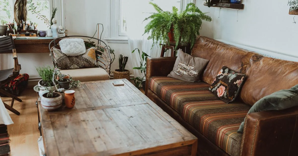 Un salon confortable avec des meubles rustiques et une végétation luxuriante pour une ambiance détendue.
